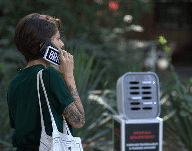 Chica usando su teléfono mientras lo carga con un Brick